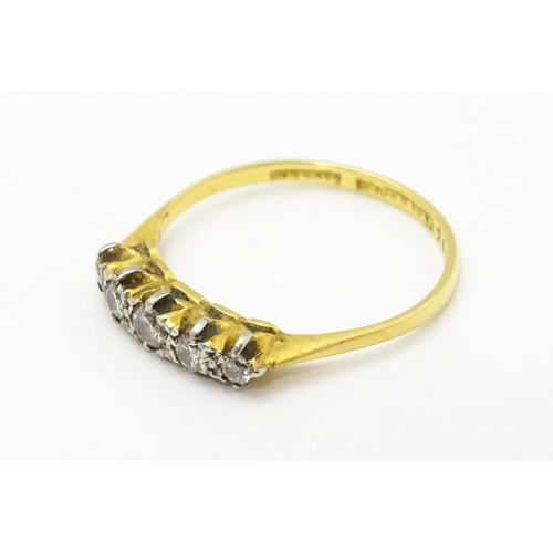 715 - An 18ct gold ring with 5 platinum set graduated diamonds.  Ring size approx P