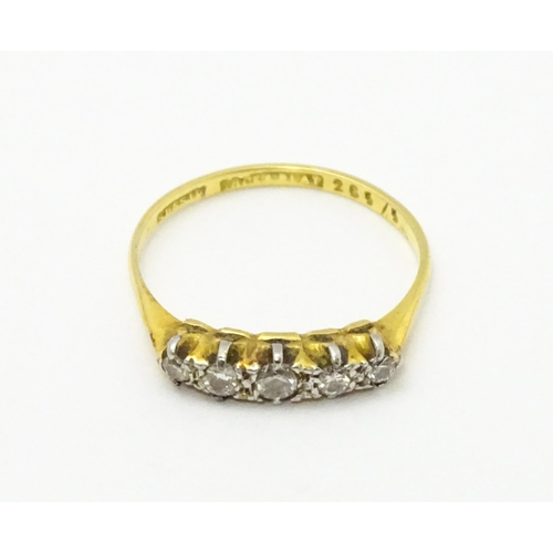 715 - An 18ct gold ring with 5 platinum set graduated diamonds.  Ring size approx P