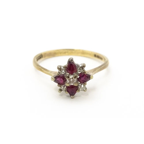 718 - A 9ct gold ring set with diamonds and red stones. Ring size approx. M 1/2