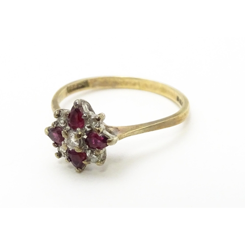 718 - A 9ct gold ring set with diamonds and red stones. Ring size approx. M 1/2