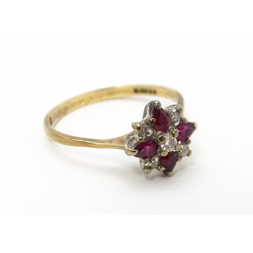 718 - A 9ct gold ring set with diamonds and red stones. Ring size approx. M 1/2