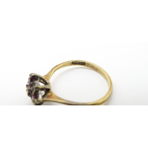 718 - A 9ct gold ring set with diamonds and red stones. Ring size approx. M 1/2