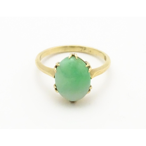 719 - A 9ct gold ring set with jade green coloured cabochon. Ring size approx L