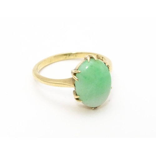 719 - A 9ct gold ring set with jade green coloured cabochon. Ring size approx L