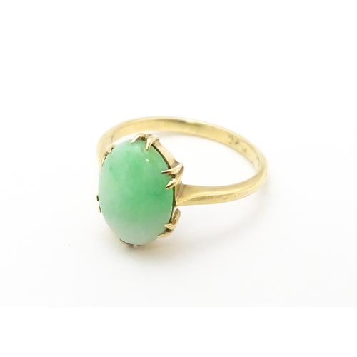 719 - A 9ct gold ring set with jade green coloured cabochon. Ring size approx L