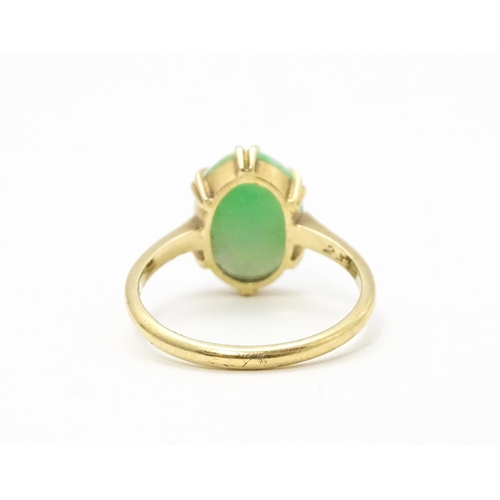 719 - A 9ct gold ring set with jade green coloured cabochon. Ring size approx L