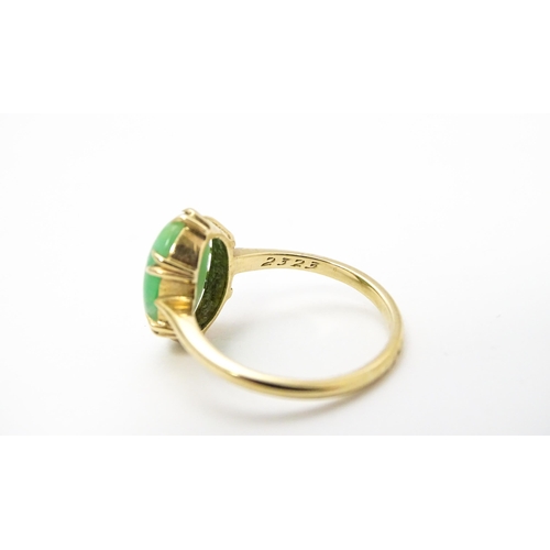 719 - A 9ct gold ring set with jade green coloured cabochon. Ring size approx L