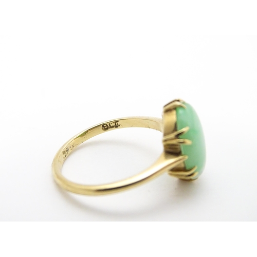 719 - A 9ct gold ring set with jade green coloured cabochon. Ring size approx L