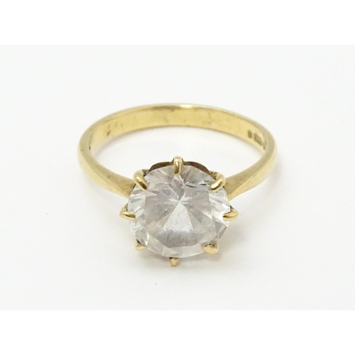 721 - A 9ct gold ring set with a white stone solitaire. Ring size approx. O