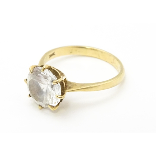 721 - A 9ct gold ring set with a white stone solitaire. Ring size approx. O