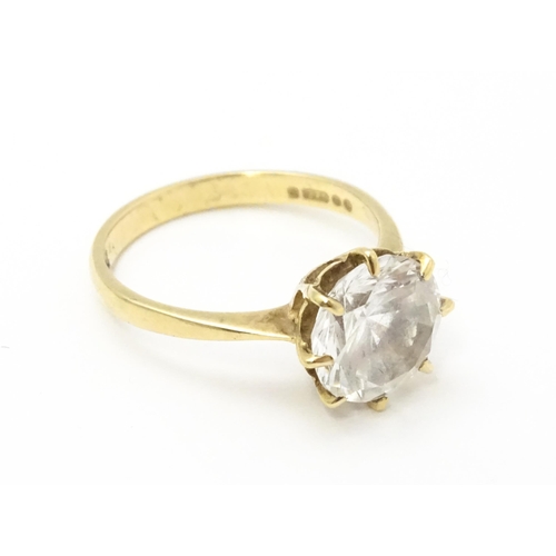 721 - A 9ct gold ring set with a white stone solitaire. Ring size approx. O