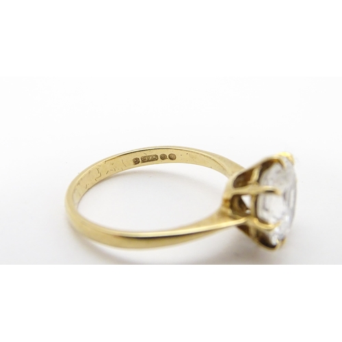 721 - A 9ct gold ring set with a white stone solitaire. Ring size approx. O