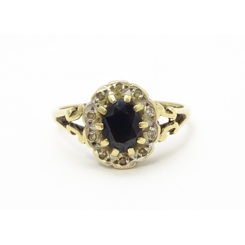 723 - A 9ct gold ring set with central sapphire bordered by diamonds. Ring size approx.  L 1/2