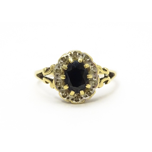 723 - A 9ct gold ring set with central sapphire bordered by diamonds. Ring size approx.  L 1/2