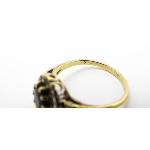 723 - A 9ct gold ring set with central sapphire bordered by diamonds. Ring size approx.  L 1/2