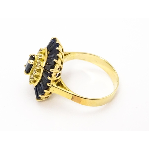 726 - A yellow metal cocktail ring set with central sapphire blue coloured stone bordered by diamonds and ... 