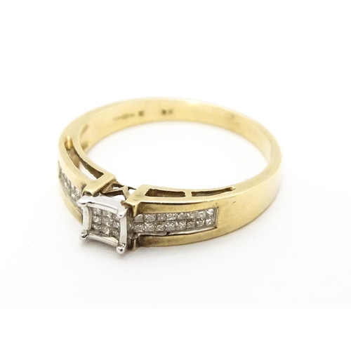 730 - A 9ct gold ring set with 9 central diamonds flanked by a further 14 diamonds to each shoulder. Ring ... 