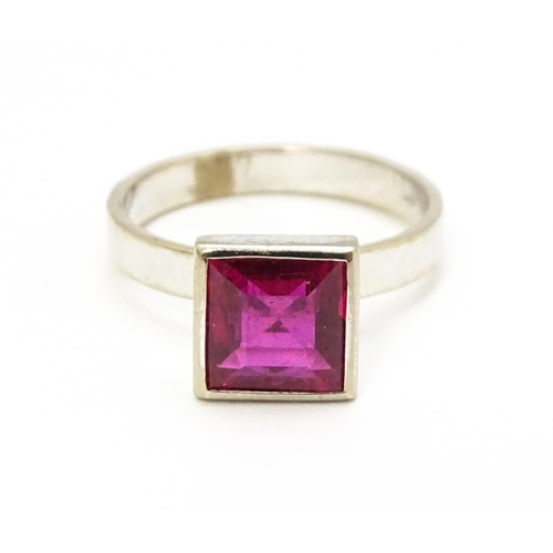 731 - An 18k white gold ring set with central square set pink/red stone. Ring size approx. N