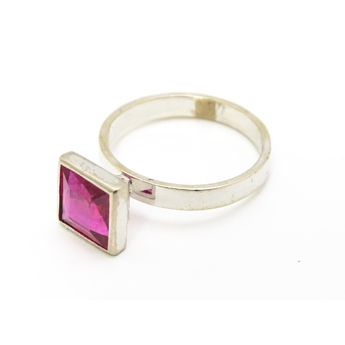 731 - An 18k white gold ring set with central square set pink/red stone. Ring size approx. N