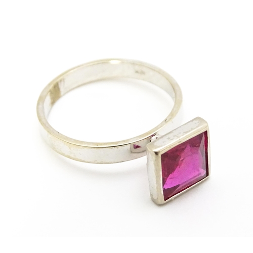 731 - An 18k white gold ring set with central square set pink/red stone. Ring size approx. N