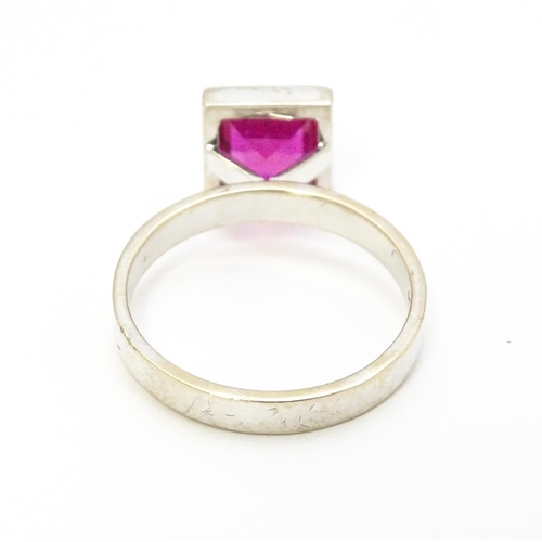 731 - An 18k white gold ring set with central square set pink/red stone. Ring size approx. N