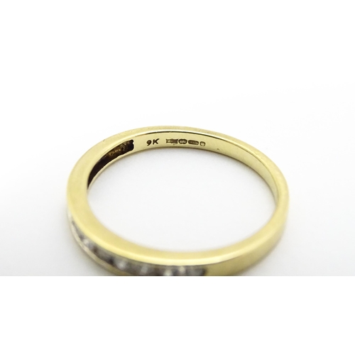 733 - A 9ct gold ring set with 9 diamonds in a linear setting. Ring size approx. P