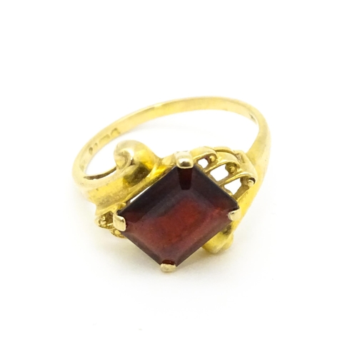 734 - A 9ct gold ring set with central garnet. Ring size approx. O 1/2