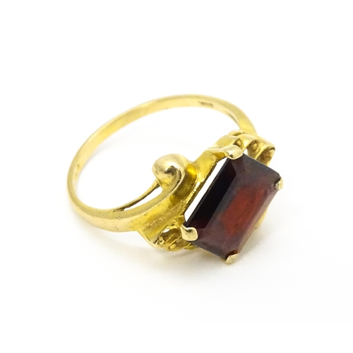 734 - A 9ct gold ring set with central garnet. Ring size approx. O 1/2