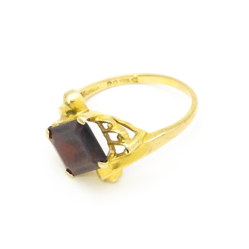 734 - A 9ct gold ring set with central garnet. Ring size approx. O 1/2