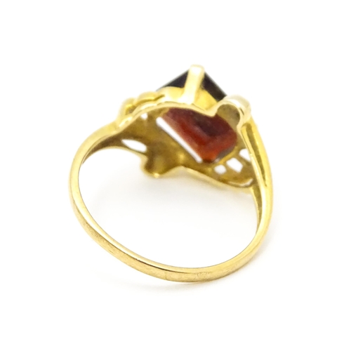 734 - A 9ct gold ring set with central garnet. Ring size approx. O 1/2