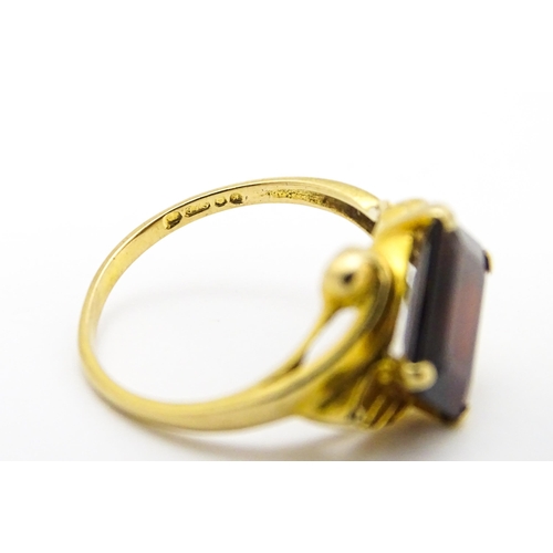 734 - A 9ct gold ring set with central garnet. Ring size approx. O 1/2