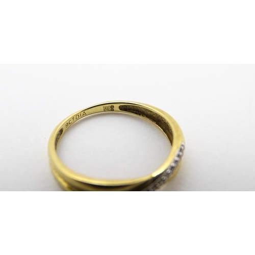 737 - A 9ct gold ring set with diamonds in a crossover setting. Ring size approx. J