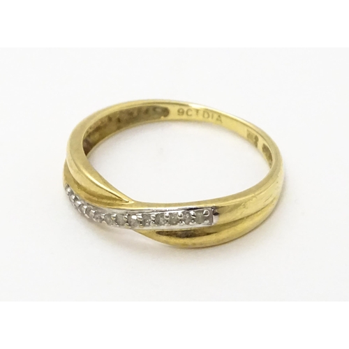 737 - A 9ct gold ring set with diamonds in a crossover setting. Ring size approx. J