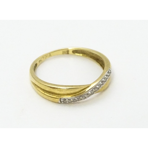 737 - A 9ct gold ring set with diamonds in a crossover setting. Ring size approx. J