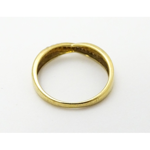 737 - A 9ct gold ring set with diamonds in a crossover setting. Ring size approx. J