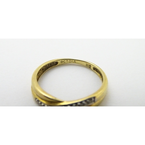 737 - A 9ct gold ring set with diamonds in a crossover setting. Ring size approx. J