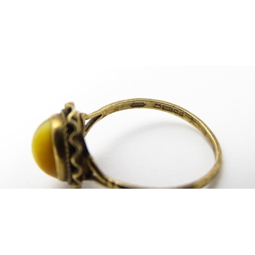 738 - A 9ct gold ring set with tigers eye cabochon. Ring size approx.  N 1/2