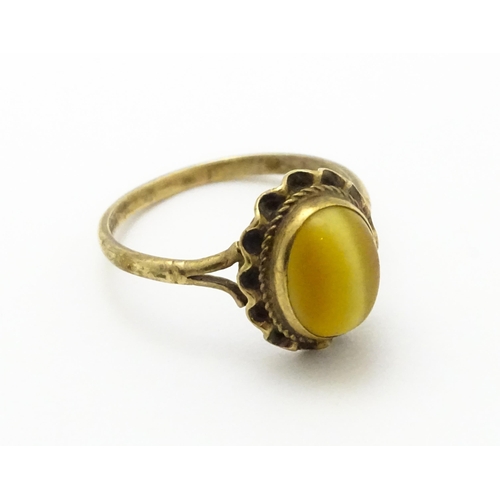 738 - A 9ct gold ring set with tigers eye cabochon. Ring size approx.  N 1/2