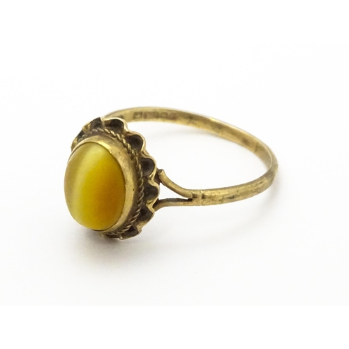 738 - A 9ct gold ring set with tigers eye cabochon. Ring size approx.  N 1/2