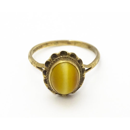 738 - A 9ct gold ring set with tigers eye cabochon. Ring size approx.  N 1/2