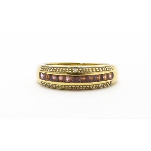 739 - A 9ct gold ring set with pink stones in a linear setting and chip set diamonds. Ring size approx. Q