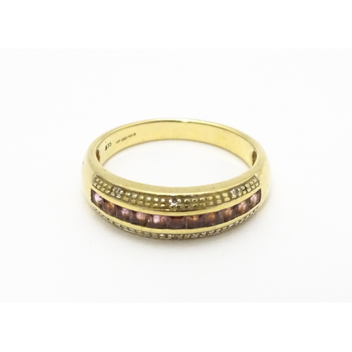 739 - A 9ct gold ring set with pink stones in a linear setting and chip set diamonds. Ring size approx. Q