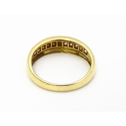 739 - A 9ct gold ring set with pink stones in a linear setting and chip set diamonds. Ring size approx. Q