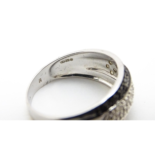 740 - A 9ct white gold ring set with banded white and black diamonds. Approx. Q 1/2