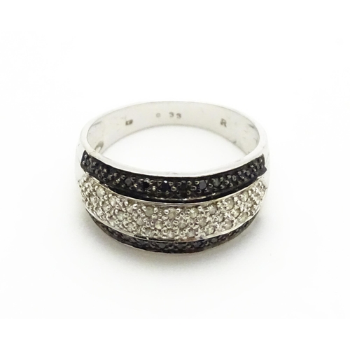 740 - A 9ct white gold ring set with banded white and black diamonds. Approx. Q 1/2