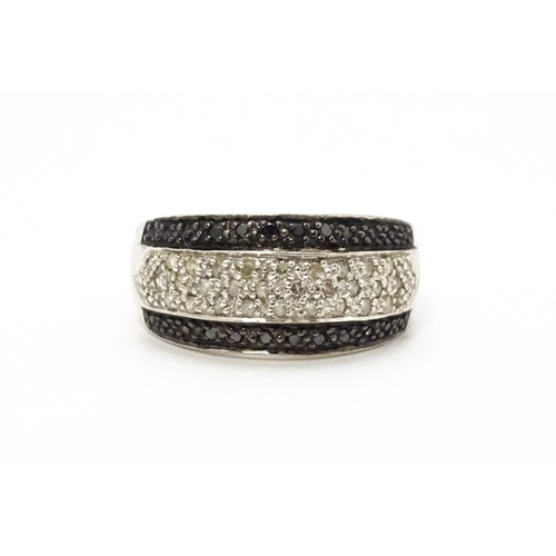 740 - A 9ct white gold ring set with banded white and black diamonds. Approx. Q 1/2