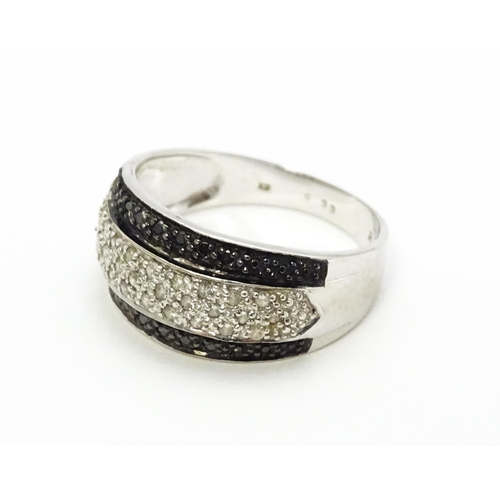 740 - A 9ct white gold ring set with banded white and black diamonds. Approx. Q 1/2