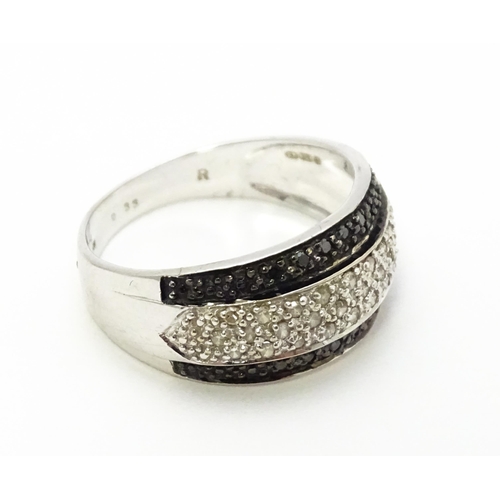 740 - A 9ct white gold ring set with banded white and black diamonds. Approx. Q 1/2