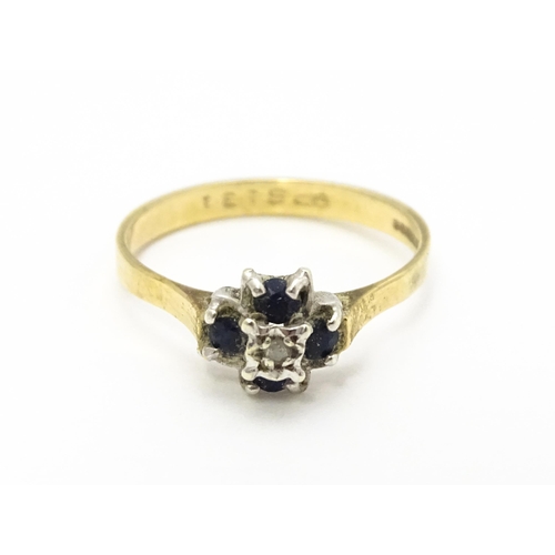 741 - A 9ct gold ring set with diamonds and blue stones. Ring size approx. L