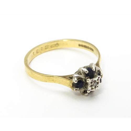 741 - A 9ct gold ring set with diamonds and blue stones. Ring size approx. L